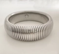 Primer plano del brazalete de resorte Tubogas plateado con textura en espiral y banda flexible - 20mm Plateado