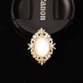 Macro detail of a vintage gold alloy brooch with white opal and sparkly rhinestones - Faux Cat Eye