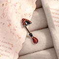 Zwarte kattenoor piercing met rode zirkoon en druppelhanger op vintage papier decor - Linkerkant Stijl (A740) / Enkel Stuk