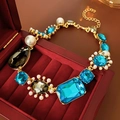 Detail of vintage gold necklace with blue and grey gemstones in a red velvet jewelry box - Necklace (Gold-Blue)