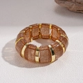 Detail of amber acrylic bracelet segments with gold glitter and metallic separators - Light Coffee