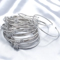 Polished silver letter bangles with sparkling zircon charms on white silk fabric - Letter A / White Gold