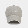 Dettaglio del ricamo STAY WILD su un cappellino da baseball vintage lavato - Beige
