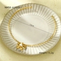 Collana dorata con fiocco e ciondolo in perla bianca posata su piatto bianco - Fiocco Perla (NMSN-A3510-1)