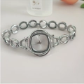 Detail view of silver floral watch with rhinestone bezel and link bracelet on white surface - Silver White Face