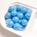 Macro shot of sky blue round acrylic beads with iridescent UV shell coating for DIY crafts - Lake Blue