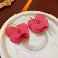 Dettaglio degli orecchini con petali rosa e ganci dorati su un vassoio perlato lucido - Rosa