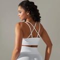 Detail of white seamless ribbed sports bra featuring criss-cross back straps for gym fitness - Cream