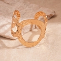 Macro detail van gouden gehamerde armband met cirkelvormige uitsparing op steen - Goud