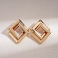Detail of interlocking golden geometric square earrings with a polished metallic finish - Gold / Gold