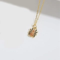 Golden spider pendant necklace featuring black and orange crystals on a delicate chain - Spider