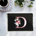 Bolsa de maquillaje negra de lona con letra D rosa y diseño floral sobre mármol - Letra D
