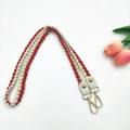 Detail of red and white woven shoulder strap with gold metal hooks and leather accents - 80cm / Red