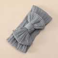 Detailed close-up of light grey cable knit baby headband with a large decorative bow - Gray