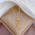 Halskette aus Titanstahl in Gold mit funkelndem Bärenanhänger auf weißer Seide - Goldener Bär mit vollem Strassstein (J134)
