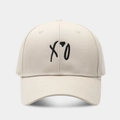 Dettaglio del ricamo XO su cappellino in cotone beige che mostra la trama del tessuto - Regolabile / Beige