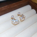 Dettaglio di orecchini a forma di cavallo dorato con inserti in conchiglia e perle lucide - Orecchini a Bottone con Perle e Cavallo a Dondolo (HE30026)
