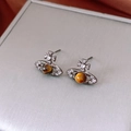 Macro shot of gunblack orb earrings featuring brown tiger eye stone and crystals - Gun Black Coffee