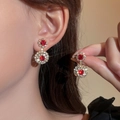 Elegant gold-tone drop earrings with vibrant red crystals and sparkling starburst effects - Gold Red