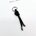 Minimalist black braided leather rope keychain with round metallic clip and cylinder charms - Black