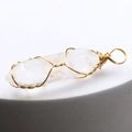 Macro shot of natural crystal hexagonal pendant with intricate gold wire wrapping details - White Crystal
