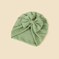 Close-up of green knitted baby turban hat with a large bow and ribbed texture - 18.5x17cm / Green