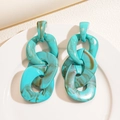 Close-up of green marble acrylic chain link earrings on a white ceramic plate - Turquoise Green