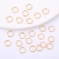 Polished 14K gold plated open jump rings scattered on white display tray for DIY jewelry - Width 4mm / 14K Gold Plated