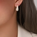 Minimalist white enamel water-drop earrings with gold-plated metal accents on female model - White