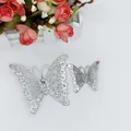 Detail of silver hollow butterfly brooches with rhinestones on a decorative background - 9cm Butterfly / Silver