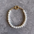 Détail de perles d'eau douce baroques avec fermoir à bascule doré sur une surface en pierre - Bracelet Style A bp4-5 (18cm)