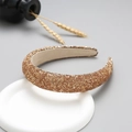 Detail of glitter golden headband displayed on a minimalist white circular ceramic stand - Rose Gold