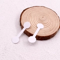 White dumbbell-shaped jewelry price tags on a wood slice for rings and bracelets - Bullet Tip / White
