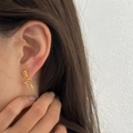 Elegant gold bow earrings set with wave design on model with clean white background - Gold