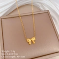 Macro view of gold bow pendant with measurements 1.2x0.9cm on beige display board - Bowknot Necklace (N127) / Gold