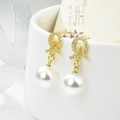 Elegante goudkleurige strik oorbellen met zirkonia en ronde witte parels voor dames - Gouden Strik met Ronde Parel