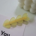 Translucent yellow heart-shaped acetate hair clip with four linked hearts and gold metal grip - Yellow