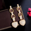 Elegante goldene Herzohrringe mit weißen Zirkonia auf dunkler Schmuckschatulle - Herz-Hänge-Stil (E2424) / Gold