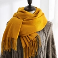 Ginger yellow soft cashmere-like scarf with tassels over a grey knitted sweater - Yellow