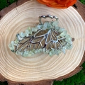 Detail of butterfly hair claw with green natural crystal stones on a rustic wood base - Prehnite Silver Butterfly