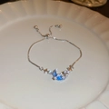 Detail van de maan en ster armband met blauwe steen en fonkelende zirkoon op wit bord - Zilver Blauwe Maan
