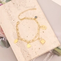 Detalle de pulsera multicapa dorada con colgantes de estrella y ojo turco en primer plano - Estilo de Dije de Mano de Fátima y Corazón Candado (7#)