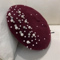 Elegant burgundy wool beret with pearl and rhinestone embellishments on a leather surface - Burgundy