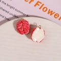 Creative red and white resin brain charms with gold loops on a white ceramic plate - Pink Brain