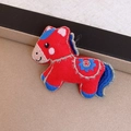 Close-up of a vintage horse brooch with red felt base and intricate embroidery details - 55# Brooch - Red - Pony