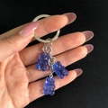 Dettaglio di tre ciondoli a forma di orsetto blu traslucido su un portachiavi d'argento - Blu Reale