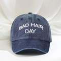 Detail shot of BAD HAIR DAY white embroidery on washed denim blue baseball cap - Navy Blue