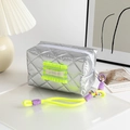 Dettaglio della trousse trapuntata argento con patch neon e cinturino intrecciato vivace - Rombo Verde Neon (Corpo Argentato/Volant Verde Neon)