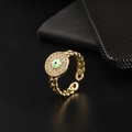 Macro shot of gold evil eye ring featuring green enamel and pavé cubic zirconia details - Style 7-Chain Green Eye Disc