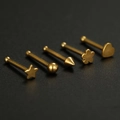 Five gold stainless steel nose studs in star, heart, and flower shapes on black background - Flower-Gold